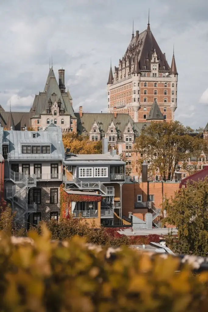 Château Frontenac towering over historic Quebec, surrounded by autumn foliage.